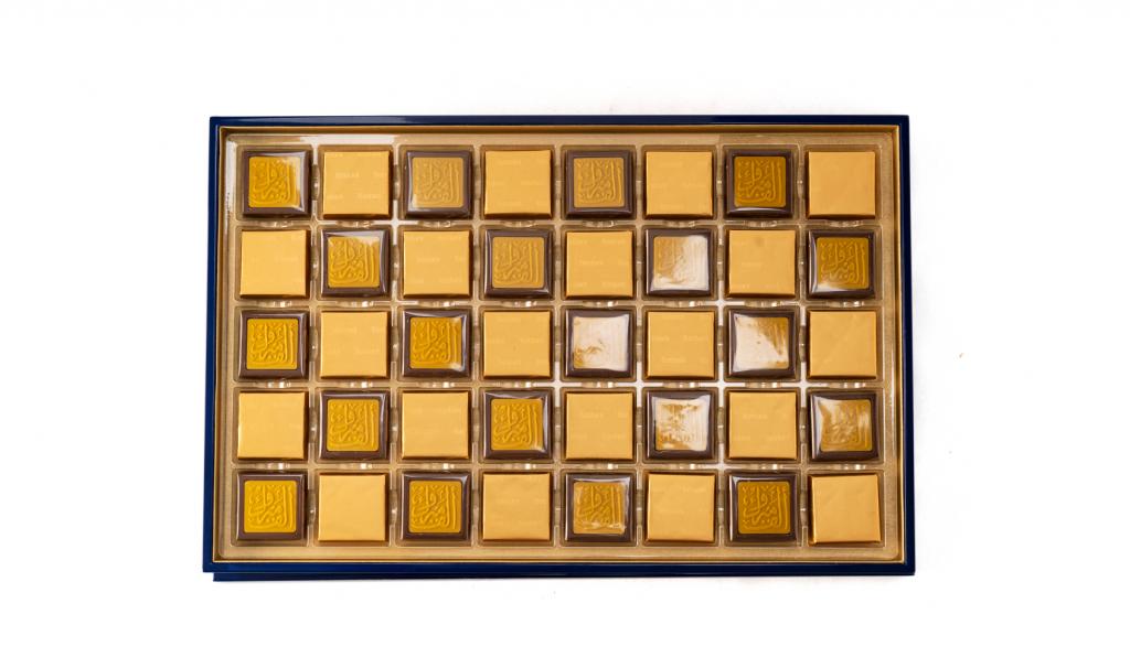 العلبة الذهبية لون كحلي مع عبارة ألف مبروك على الشوكولا 80 حبة 